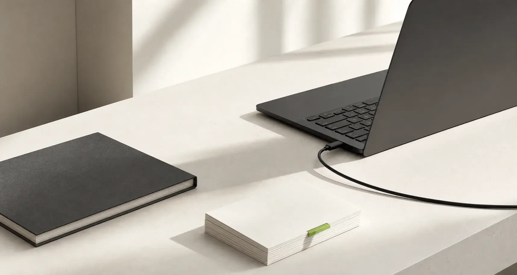 Minimal workspace with a laptop, notebook and organised workflow cards